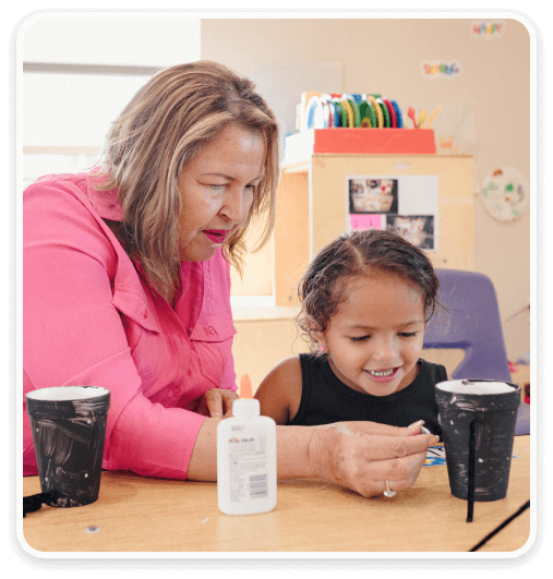 Decorative image of Maria Melendez in classroom with student doing crafts