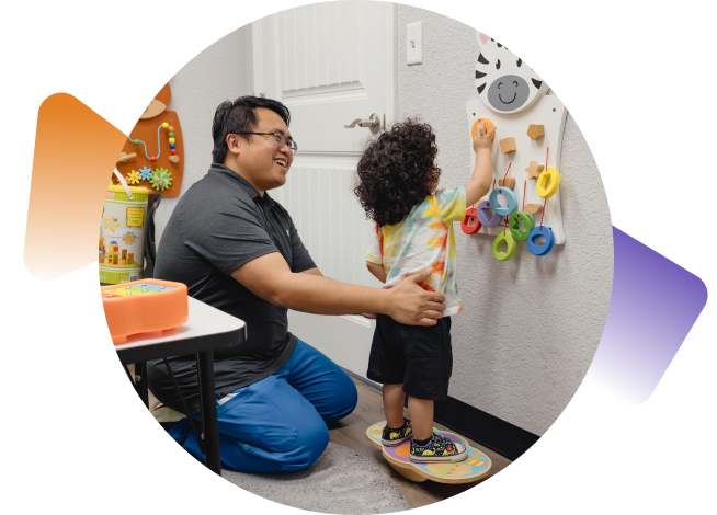 Jason Coloma, fisioterapeuta, ayuda a un niño pequeño a practicar el equilibrio y la coordinación.