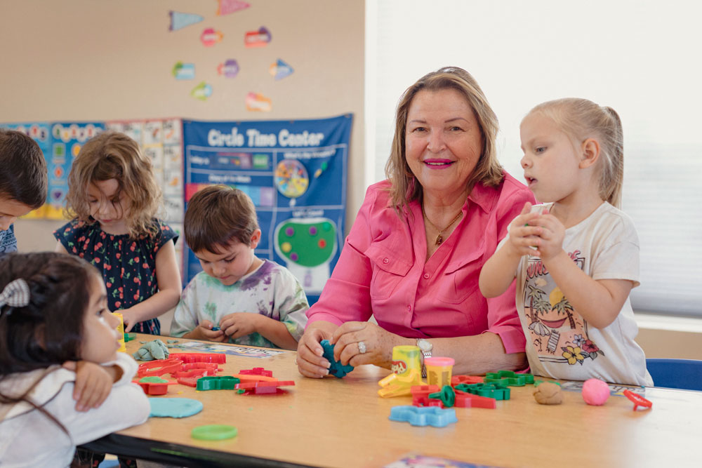 Maria Melendez, emprendedora de la primera infancia, juega con Play-Doh junto con sus estudiantes.