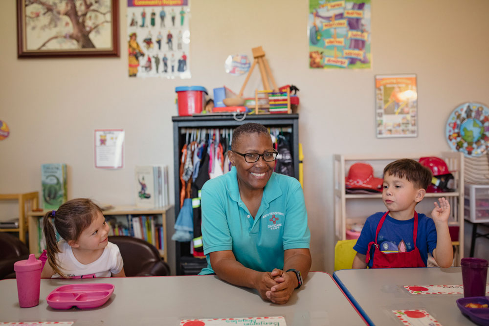 Early childhood educator Valeria Holloway poses in her home with her students