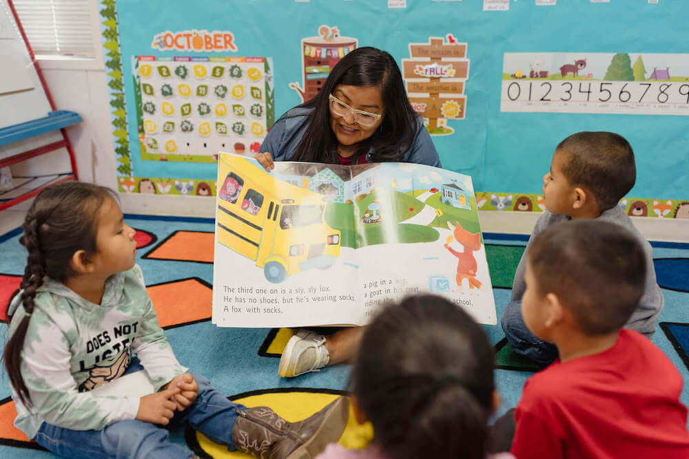 PreK Educator Arlissa Francisco reading an illustrated book to her students