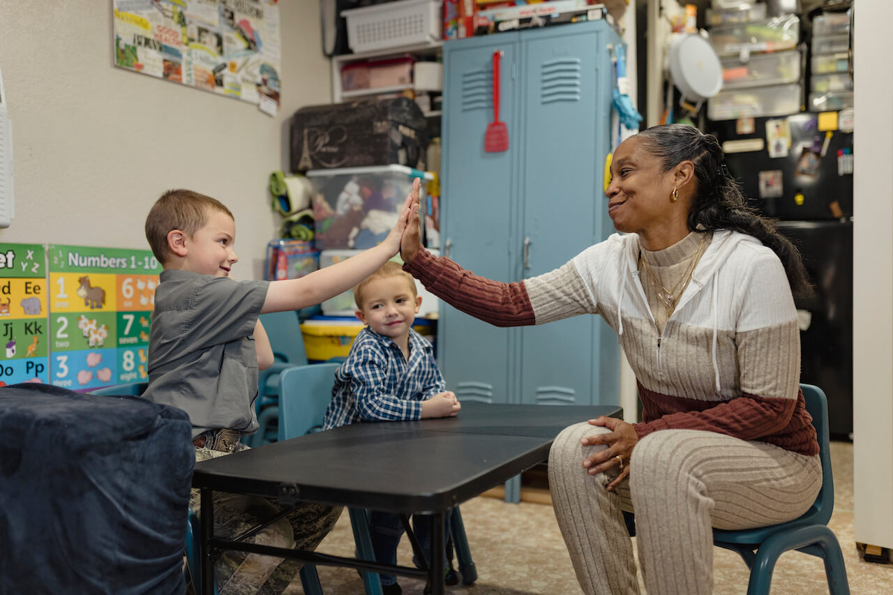 Early childcare provider, Je'Nette McDonald gives a high five to one of her students.